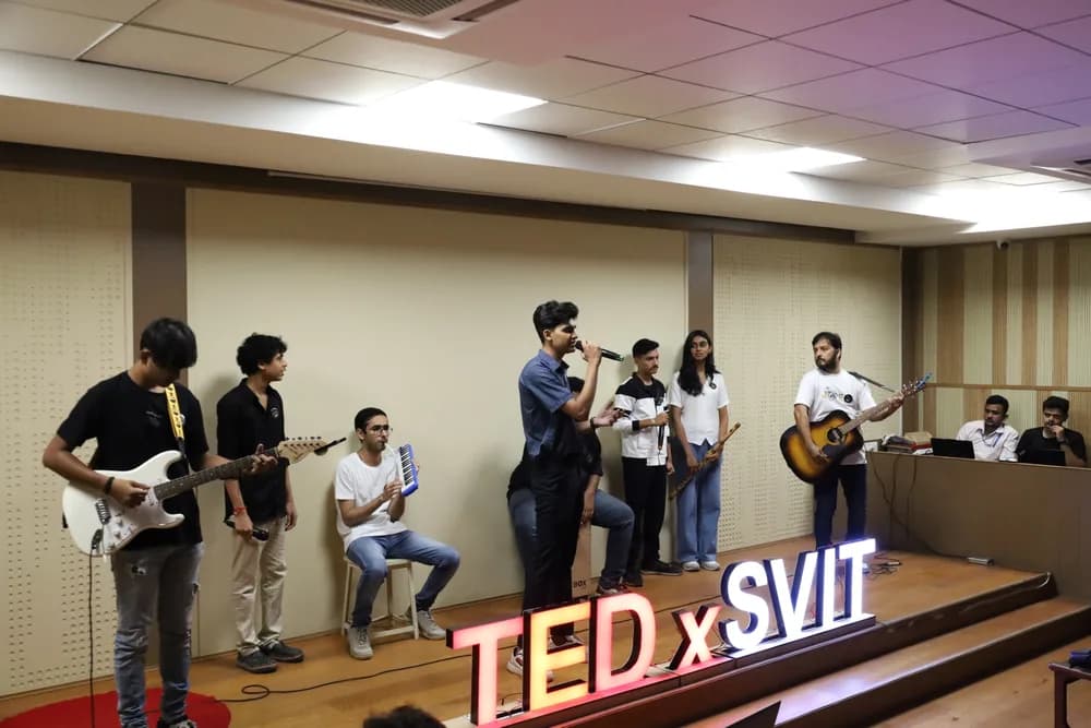 The house band performing on stage beside the TEDxSVIT marquee